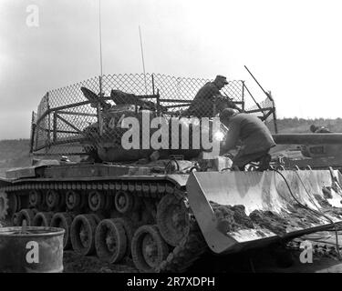 An M-46 Patton tank dozer of Dog Company, 1st Tank Battalion, with a wire fence cage around the turret, which was designed to explode 3.5 rockets the enemy is firing before they hit the tank.  The wire fence turns with the turret. Stock Photo