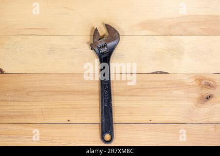 Metal adjustable wrench on wooden background. Stock Photo