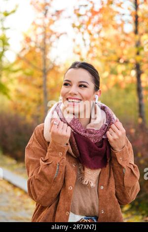 caucasian-young-woman-listening-music-with-earphones-smiling-in-autumn-2r7xn7j.jpg