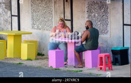 Galle, Sri Lanka - 02 15 2022: Beautiful couple enjoying an evening snack sitting on an outdoor table. Stock Photo