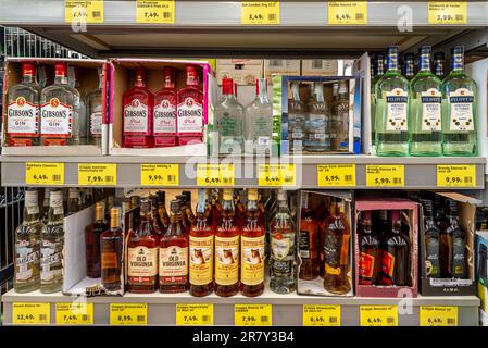 italy - june 15, 2023: bottles of Bourbon Whiskey, schoth whisky and Gin and rum in open cardboard boxes on shelf for sale at low prices in discount s Stock Photo
