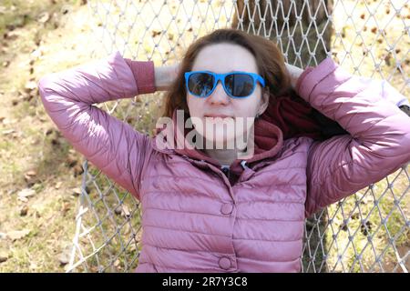 Woman lying in hammock in park in spring Stock Photo