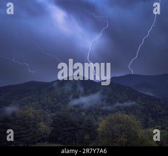 Dramatic storm clouds illuminated by intense lightning strikes. Stock Photo