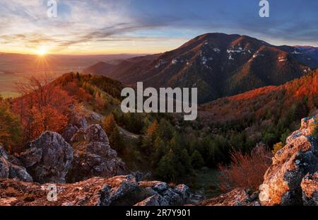 Mountain at sunset with sun and forest Stock Photo