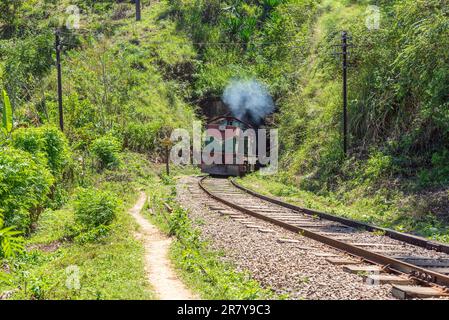 Shortly behind the nine arches bridge between Demodara and Ella, the track leads through a tunnel. The locomotive is on the way to Ella, in the Stock Photo