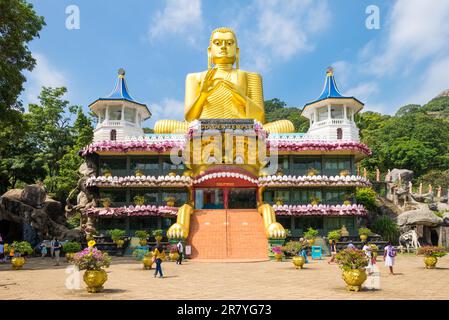 Huge golden Buddha statue on top of the Buddhist Museum of the Golden Temple Dambulla. The holy place is visited from believers, tourists and locals Stock Photo