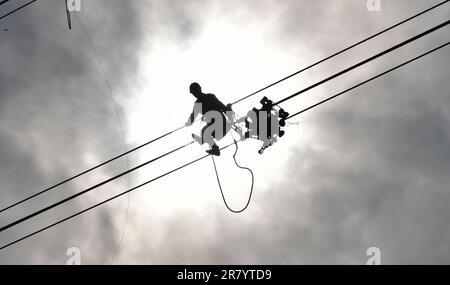 Beijing, China's Liaoning Province. 15th June, 2023. An electrical engineer works on an overhead power line in Chaoyang City, northeast China's Liaoning Province, June 15, 2023. Credit: Yang Qing/Xinhua/Alamy Live News Stock Photo