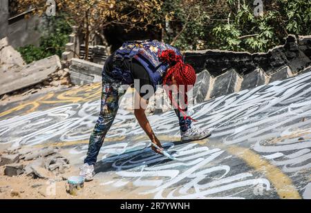 Gaza, Palestine. 17th June, 2023. A Palestinian artist, Ayman Alhossary finalizes Arabic calligraphy drawings on the remnants of a house destroyed by Israeli air strikes in Beit Lahia, northen Gaza Strip. Credit: SOPA Images Limited/Alamy Live News Stock Photo