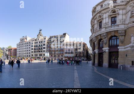 Bilbao, Spain - April 15, 2022: Plaza del Arriaga in Bilbao with groups of tourists waiting for a tour with the facade of the Arriaga or Antzokia Thea Stock Photo
