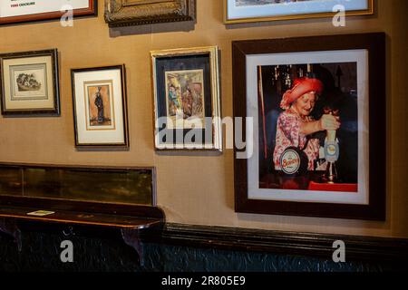 Photo of the Queens Mother pulling a pint in the traditional pub Guinea Grill in Mayfair,London , United Kingdom Stock Photo