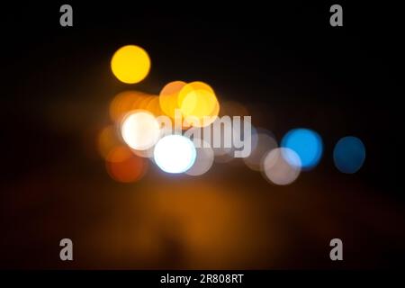 Blurred defocused lights at night. Abstract blur vehicle coming at night in the city. Stock Photo