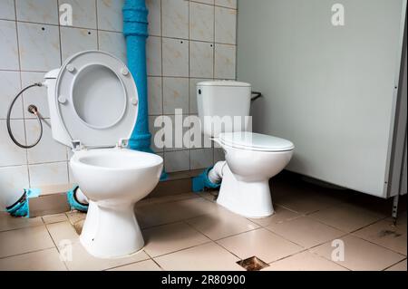 Two toilets side by side. Toilet for two. There are two toilets next to each other. Place to talk Stock Photo