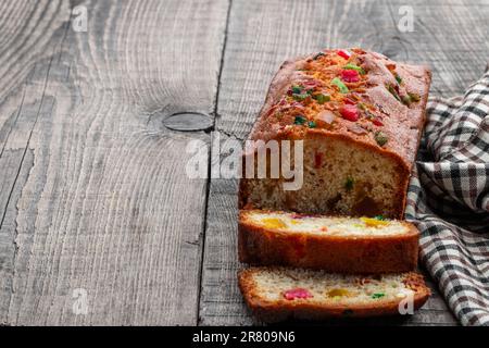 Fresh  sliced homemade fruit cake with candied fruits on wooden table Stock Photo