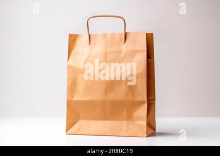 Paper bag. Craft paper shopping bag. Brown folded paper bag with handle. Empty grocery paper bag. Stock Photo