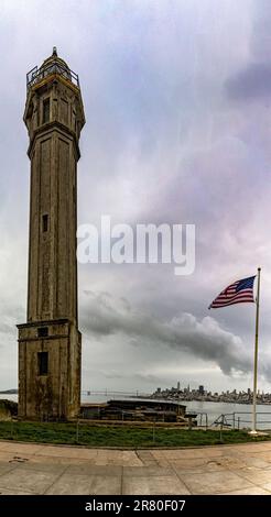 Lighthouse and American flag of the maximum security federal prison of Alcatraz located in the middle of the San Francisco bay. Stock Photo