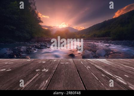 Fast mountain river flowing with empty wooden batten bridge. Natural ...