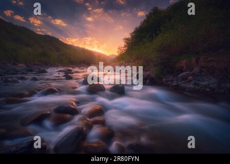 Magical sunrise over fast flowing mountain river with empty wooden ...