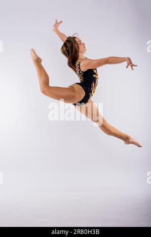 High jump, flight. Little flexible girl, rhythmic gymnastics artist