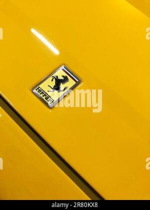 Izmir, Turkey - May 16, 2023: Close-up view of a 1990 Ferrari car logo on a bright yellow background, capturing the timeless luxury and elegance of th Stock Photo