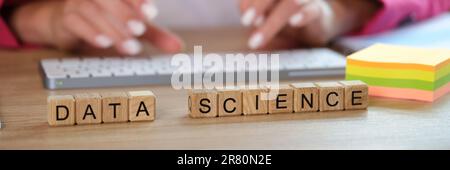 Hands typing on keyboard and data science text on cubes Stock Photo