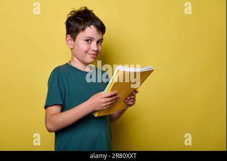 Handsome teenage boy smiling looking at camera, holding textbooks, ready to start a new semester of academic school year Stock Photo