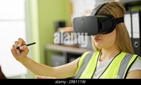 Young blonde woman architect using virtual reality glasses drawing at office Stock Photo