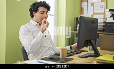 Young latin man business worker having breakfast at office Stock Photo