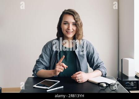 Young Professional Engaged in a Video Conference, Communicating with Confidence through a Web Camera from Office or Home. Life Coaching and Online Stock Photo
