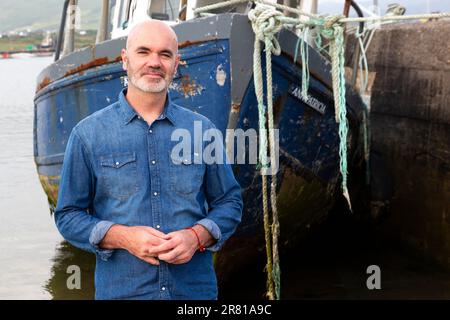Tall bald man with white beard and denim shirt Stock Photo