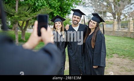 Group of people students graduated taking photo by smartphone at university campus Stock Photo