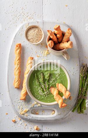 Green and creamy creamy asparagus soup as starter in restaurant. Veggie soup made of vegetables. Stock Photo