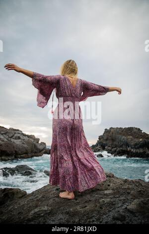 Photo from back of girl with arms raised Stock Photo - Alamy