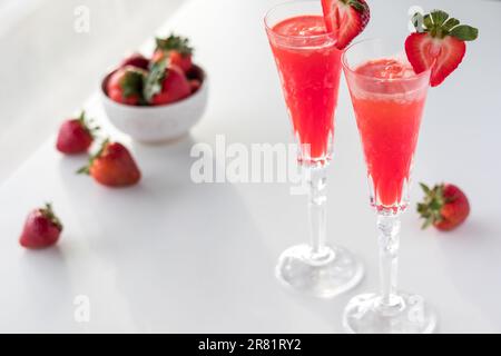 Refreshing strawberry mimosas with a bowl of strawberries. Stock Photo