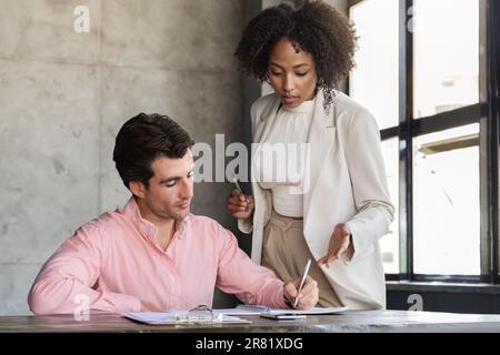Black woman secretary and young caucasian man manager at office Stock Photo