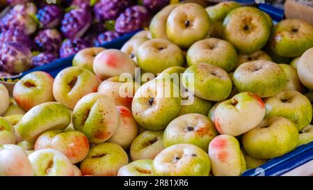Marzipan fruits assortment. Close up of marzipan sweets shaped and painted as flat peach in patisserie shop. Martorana fruit is typical Sicilian Stock Photo