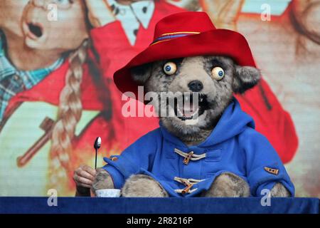 The cast of Idiot’s Assemble: Spitting Image The Musical with a caricature puppet of Paddington Bear performing live on stage at West End Live 2023 in Trafalgar Square, London, England. Stock Photo