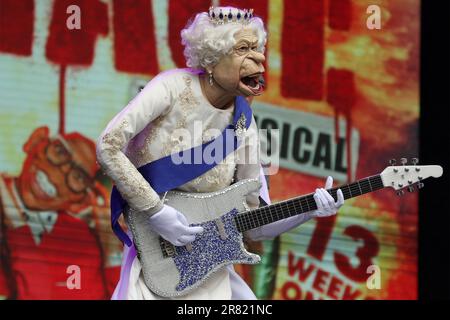 The cast of Idiot’s Assemble: Spitting Image The Musical with a caricature puppet of Queen Elizabeth the second playing guitar performing live on stage at West End Live 2023 in Trafalgar Square, London, England. Stock Photo