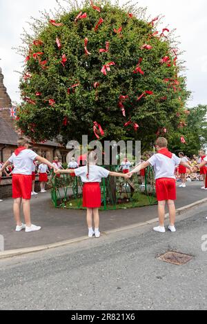 17 June 2023 – Appleton Thorn, nr Warrington, Cheshire, England. Bawming (decorating the tree with flowers and ribbons) the thorn is an annual ceremony that takes place in the village of Appleton Thorn in Cheshire, England. Appleton Thorn village is the only village in England where the ‘Bawming of the Thorn’ ceremony takes place on the third Saturday of June each year. Children from year 6 of Appleton Thorn Primary School danced around the Torn Tree whilst singing the Bawming Sang. Stock Photo