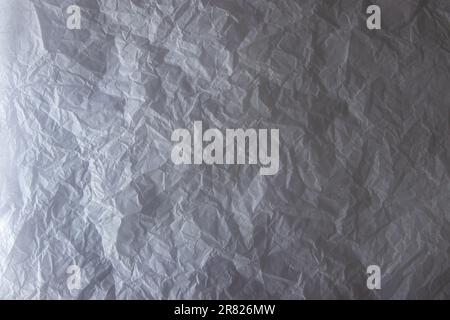 Crinkled white wrapping paper. Light and shadow contrast background. Stock Photo