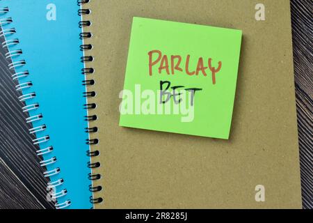 Concept of Parlay Bet write on sticky notes isolated on Wooden Table. Stock Photo