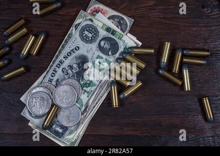 Old west period US banknotes and silver certificates with silver dollar coins and .45 caliber revolver ammunitions background Stock Photo