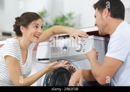 happy smiling young couple choosing washing machine Stock Photo