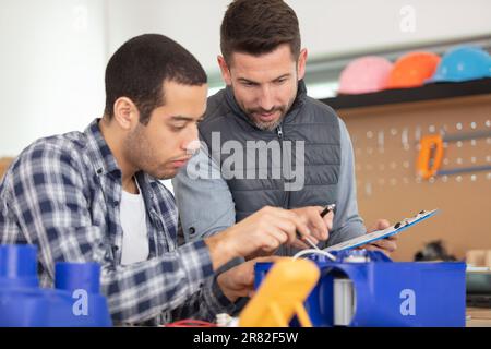 trainee electrician is repairing a device Stock Photo