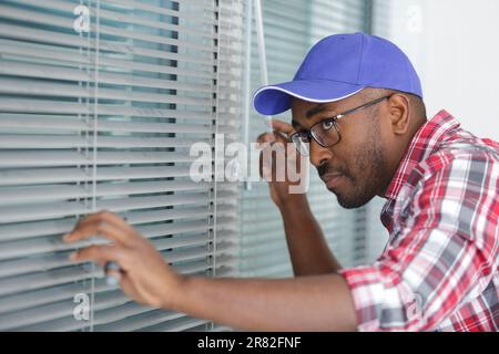 young worker repairing window in flat Stock Photo