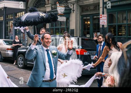NEW ORLEANS, LA, USA - JUNE 3, 2023: Wedding party with bride and Groom parading on Chartres Street in the historic French Quarter Stock Photo