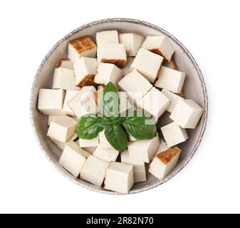 Bowl with delicious smoked tofu and basil on white background Stock Photo