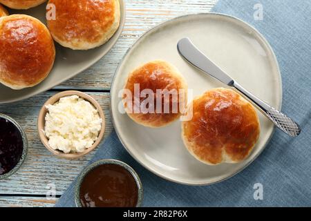 Tasty scones prepared on soda water, chocolate paste, jam and cottage cheese on wooden table, flat lay Stock Photo