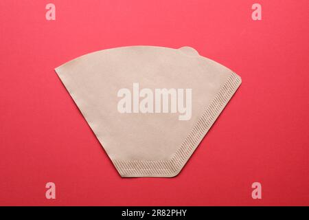 Paper coffee filter on red background, top view Stock Photo