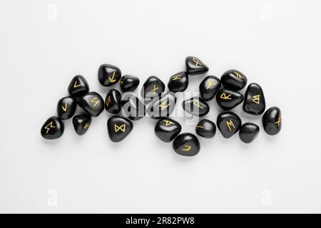 Black rune stones on white background, top view Stock Photo