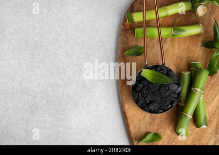 Fresh bamboo and charcoal on light gray table, flat lay. Space for text Stock Photo